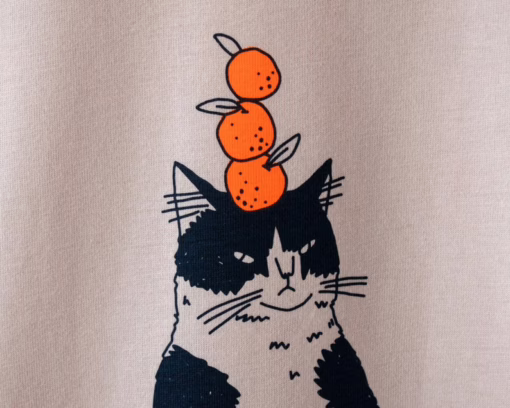 Orange Cat t-shirt | Hand screen printed illustration of a cat balancing oranges on misty pink organic cotton tee with navy and orange