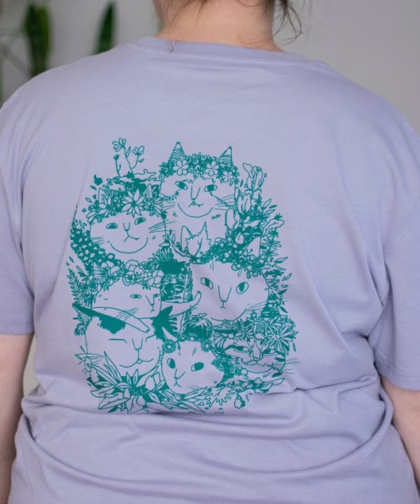 Summer Bouquet T-Shirt | Hand screen printed illustration of 7 cats with flowercrowns and other plants in green on lilac organic cotton tee